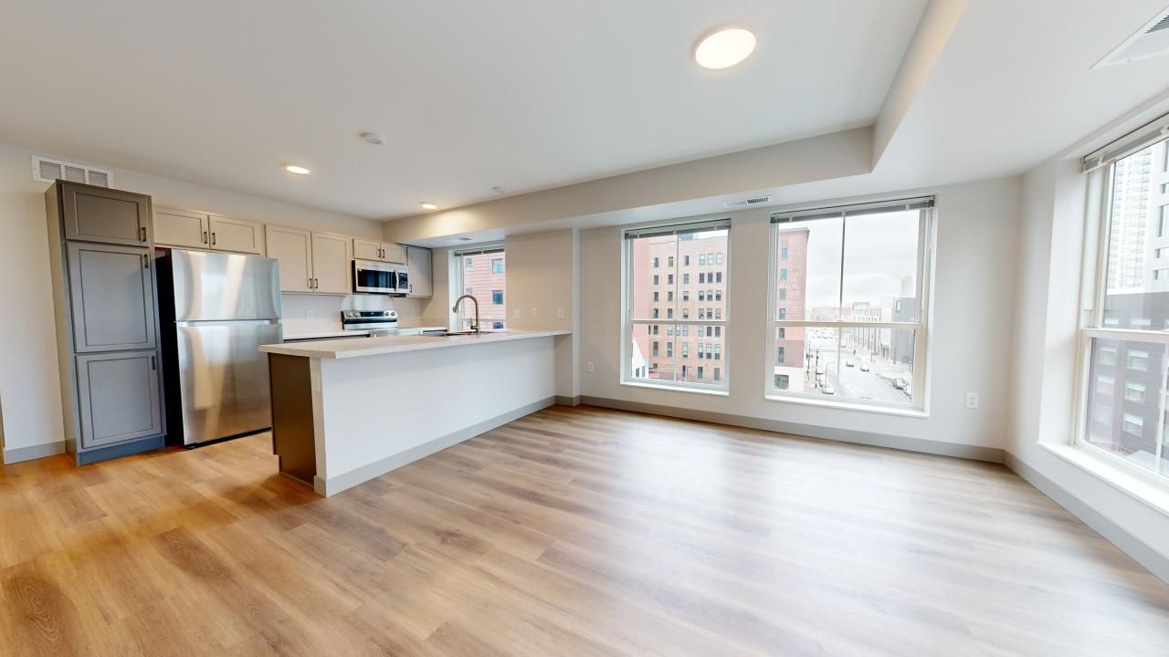 Ladder 260 apartment interior with kitchen island and large windows offering views of Minneapolis skyline