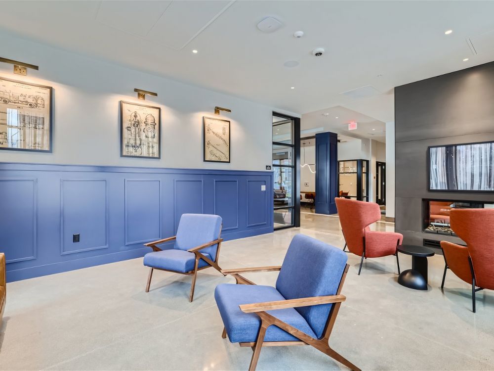 The stylish lobby of Ladder 260 featuring blue panel walls, modern seating, and framed artwork.