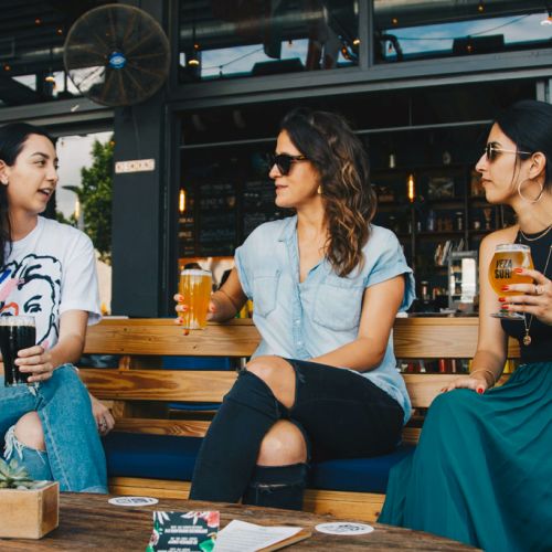 Friends sharing drinks on back porch of a restaurant 